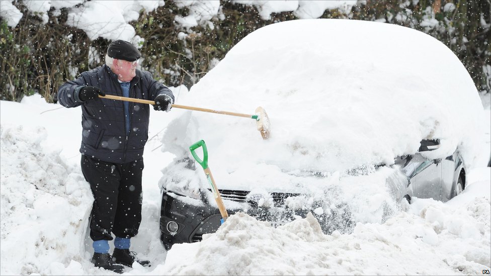 old man diggin out car from snow