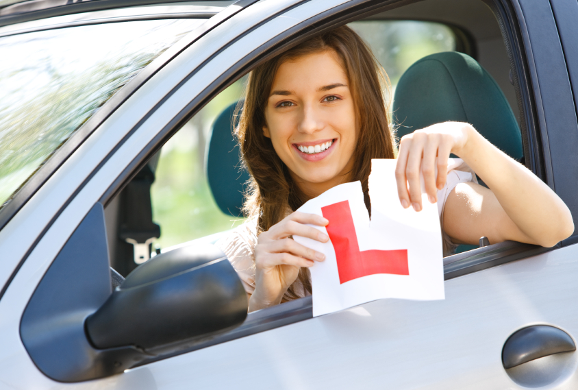woman ripping the learning driver sign
