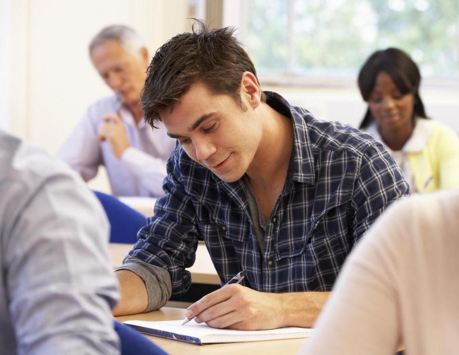 man in a checkered shirt and other people at exam