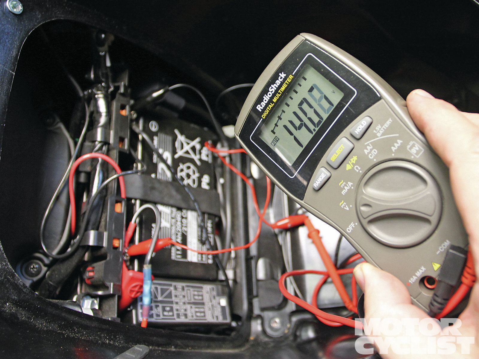 man chacking motorcycle battery charge