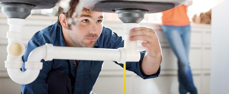 plumber fixing sink pipes