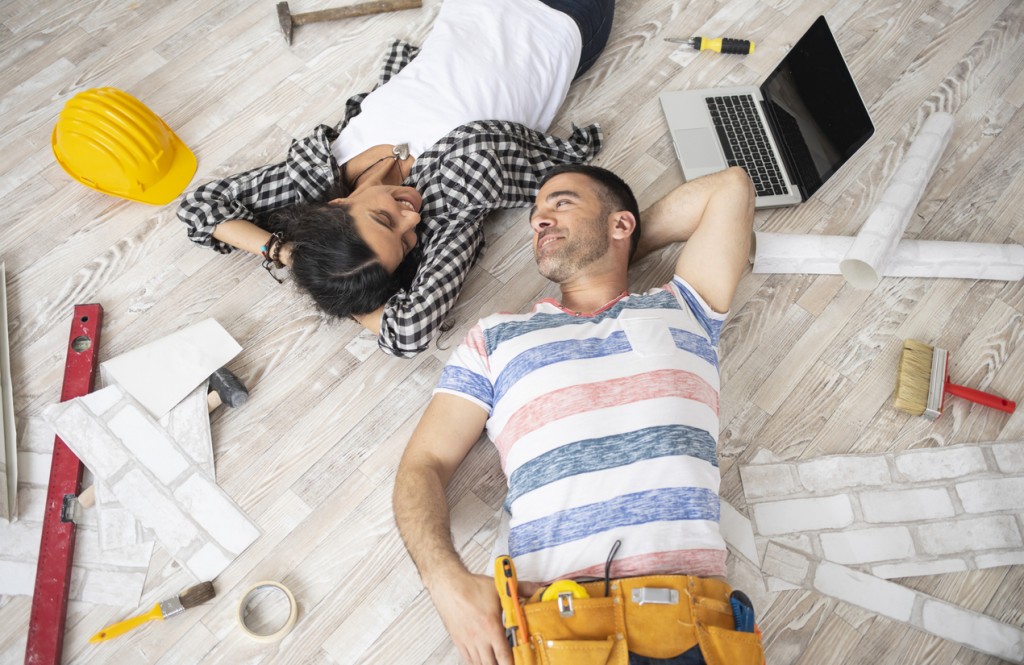 Couple lying on the floor in new home, looking at each other.