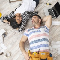 Couple lying on the floor in new home, looking at each other.