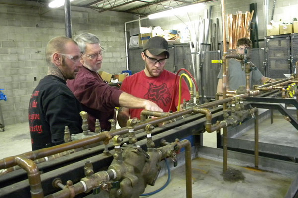 men teaching plumbing programm