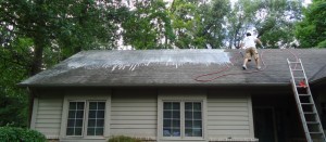 man on roof washing it