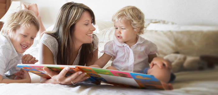 babysitter with two kids reading a book on the bed find a job