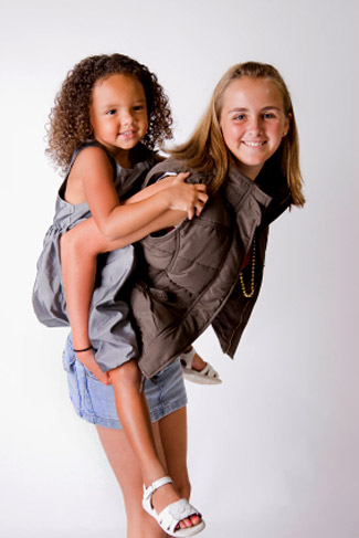 teen babysitte holding a girl on her back