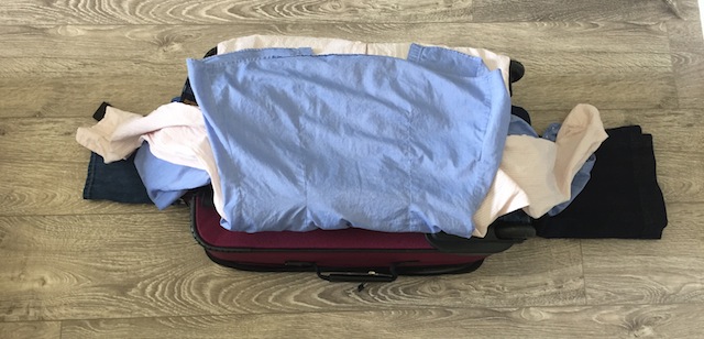 making a bundle of clothes to pack a suitcase