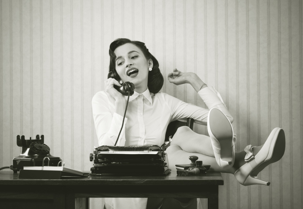 woman talking on the phone with legs on the desk