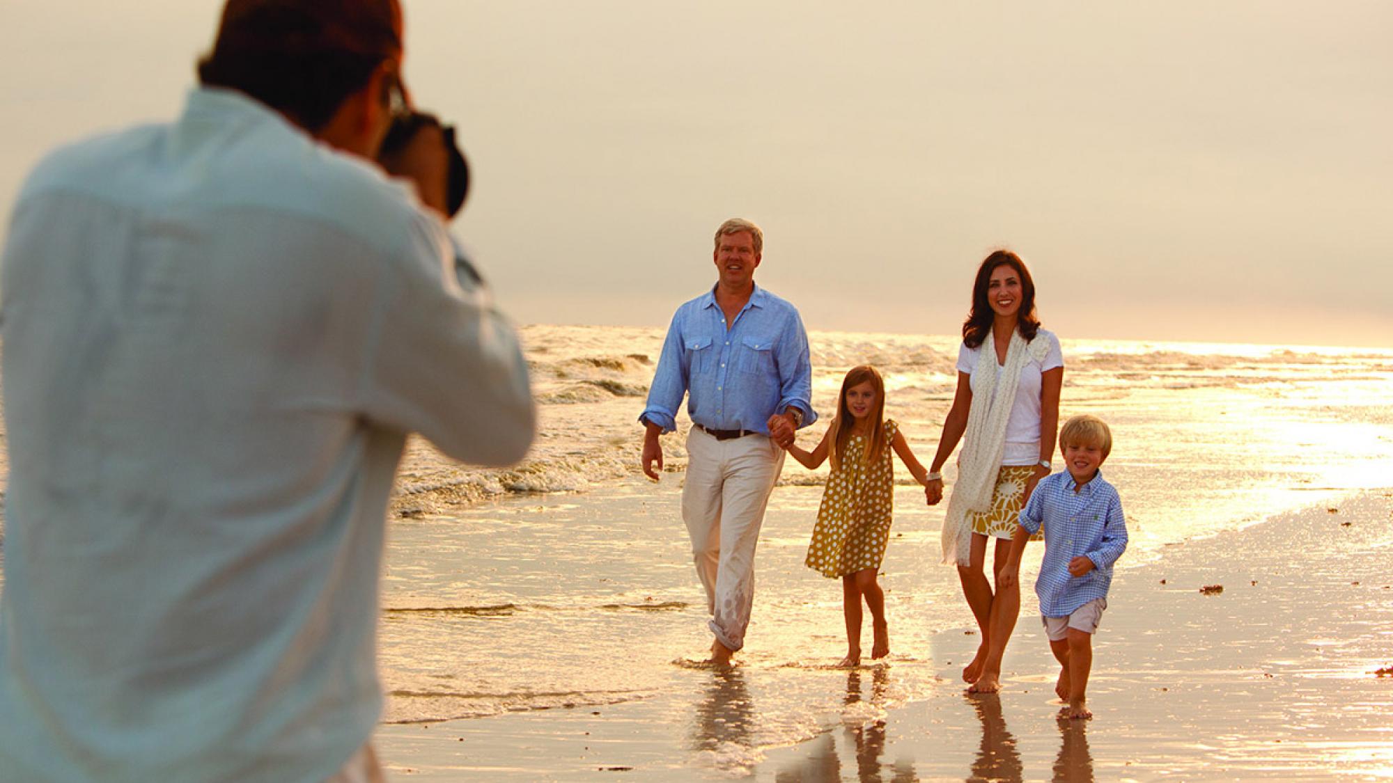 photographer taking family photo on the beach