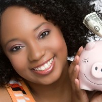 teenage girl smiling holding a pink piggy bank