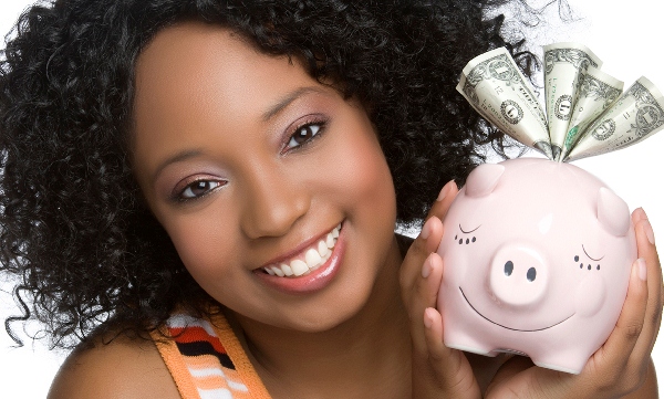 teenage girl smiling holding a pink piggy bank
