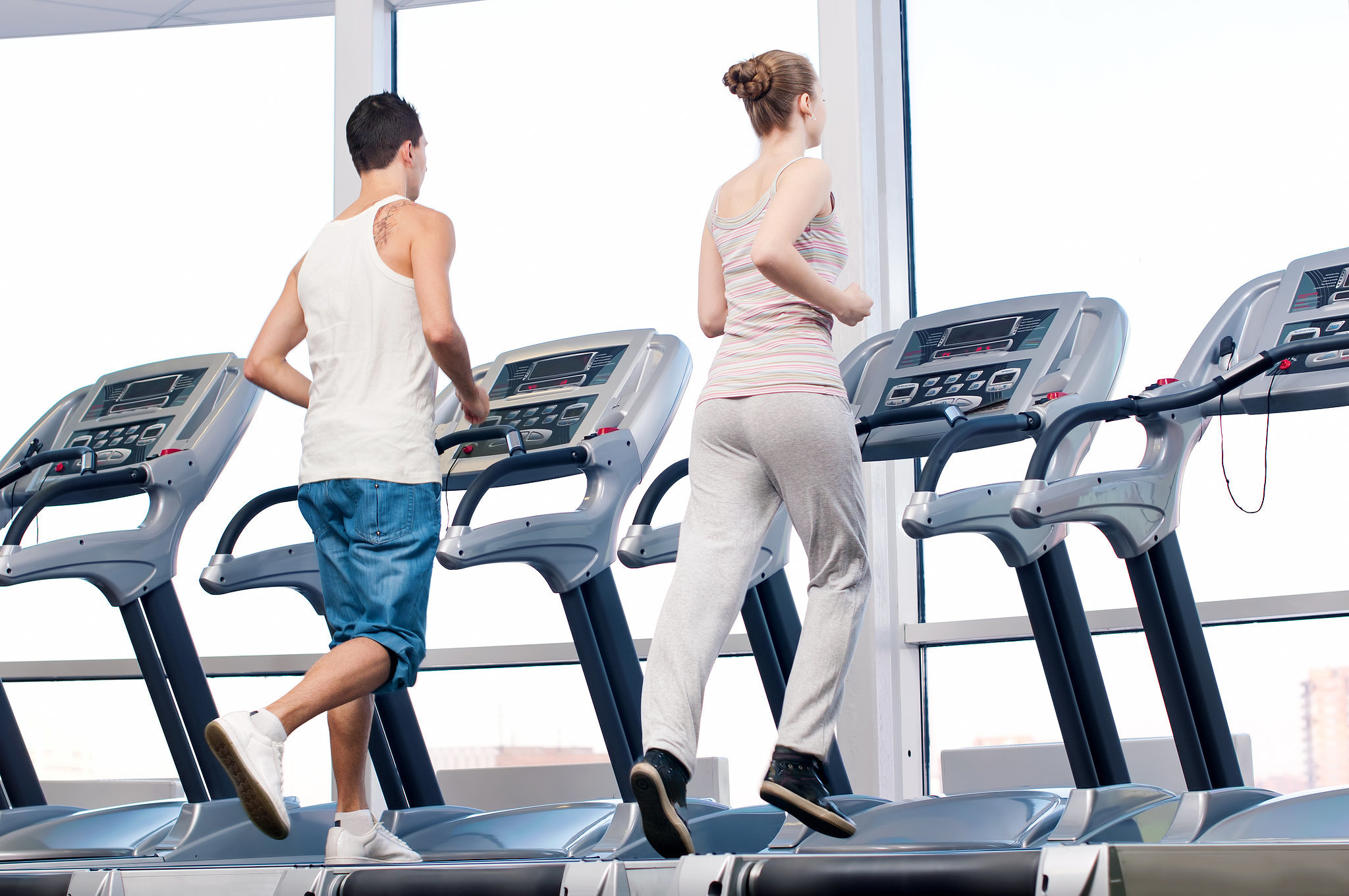 man and woman running on a treadmill