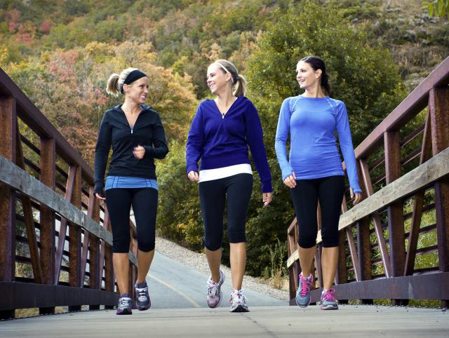 3 women in gym clothes walking along the bridge