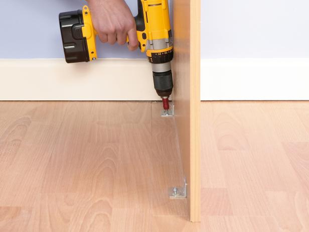 man attaching a side pannel of a closet