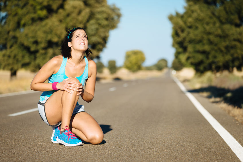 woman kneeling on the road due to the running knee injury