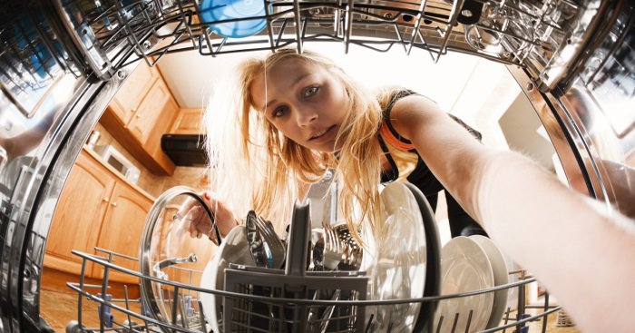 woman looking inside a dishwasher