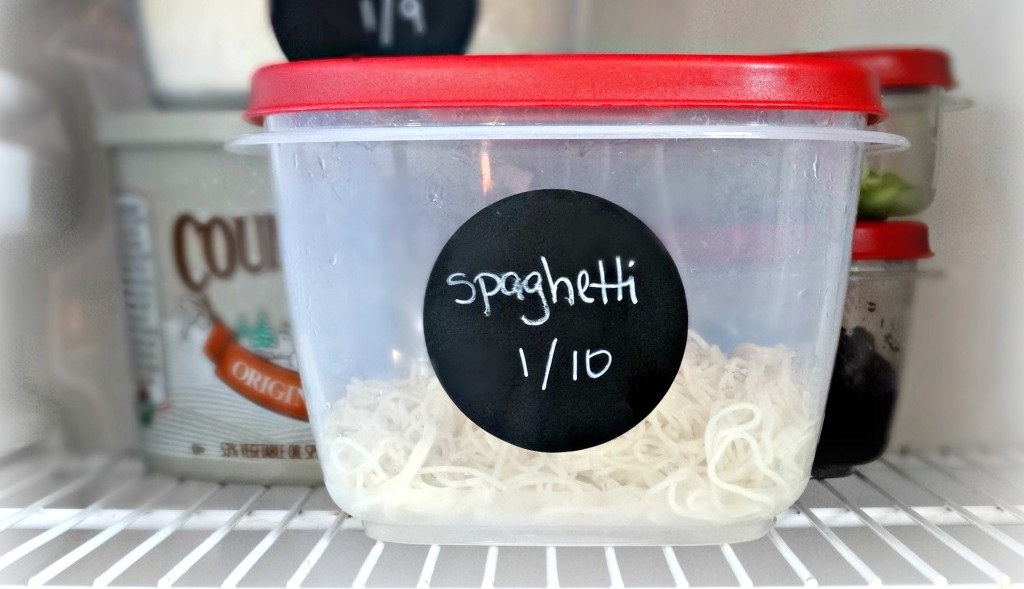 organizing refrigerator chalk boarl labels with date on container with leftovers