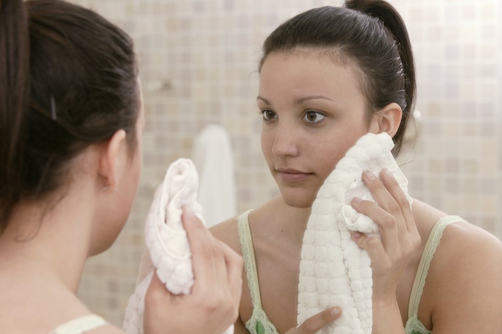 woman drying her face with a towel