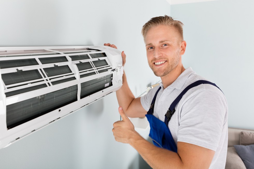 Smiling Male Electrician Gesturing Thumbs Up Near Air Conditioner